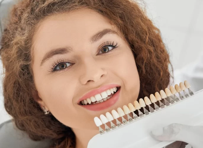 woman-smiling-while-male-dentist-keeping-teeth-color-range